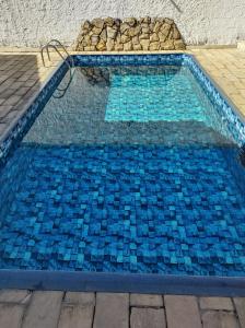 阿帕雷西达Chácara Bom Jesus的铺有蓝色瓷砖的游泳池