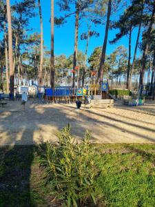 波讷地区圣朱利安Mobil-home Les Dunes de Contis的公园内有长椅和树木的游乐场