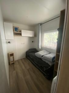 波讷地区圣朱利安Mobil-home Les Dunes de Contis的小房间设有两张床和窗户