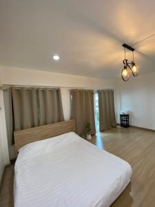 Thung Si KanThanyaporn Guest House - Don Mueang的卧室配有一张白色大床
