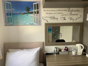 德罗伊特威奇Enjoy your stay at Chorley Road的一间卧室配有一张带镜子的床和一张四柱床