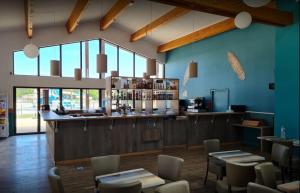 波讷地区圣朱利安Mobil-home Les Dunes de Contis的餐厅设有酒吧和桌椅