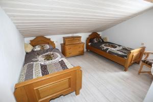 ZlemHaus Grimmingblick的一间卧室设有两张床,铺有木地板