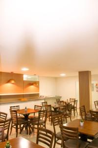佩内杜Hotel Rochedo AL的用餐室配有木桌和椅子