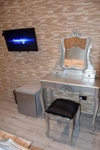 El BiarGhazalle Oasis Hotel 1的一张桌子、椅子和墙上的电视
