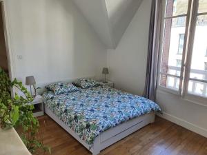 昂吉安班斯2 chambres dans une maison proche de Paris et du Stade de France的一间卧室配有一张带蓝色棉被的床