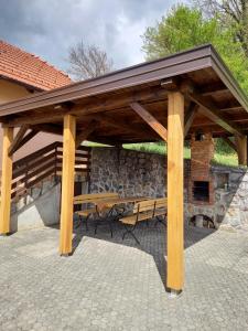 GradacPeaceful, cosy cottage near Kolpa river的木亭子,配有野餐桌和石墙