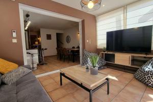 LecciPlage à pied : Mini villa Saint-Cyprien的带沙发和大屏幕平面电视的客厅