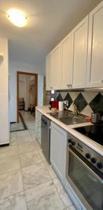 尼基季Villa eco Electra的厨房配有白色橱柜和炉灶烤箱。