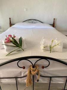 尼基季Villa eco Electra的一张铺有白色床单和鲜花的床