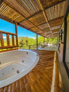 HispaniaHuitaca Ecohotel的木制甲板上设有大型浴缸,屋顶