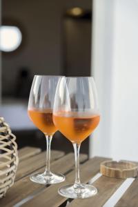 波萨达Sunrise Sardinia Posada的木桌上放两杯酒杯