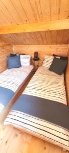 斯维诺乌伊希切Ostoja Struga的小屋内的两张床,设有木制天花板