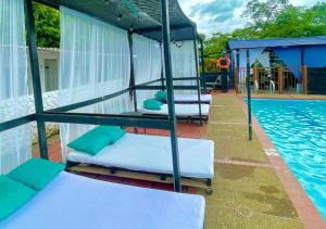 比亚维森西奥Llano Dorado Hotel Campestre的一组床,位于游泳池旁
