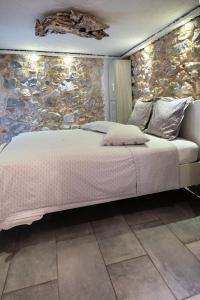 雅典Stone House的一间卧室设有一张带石墙的大床