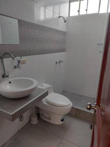 阿亚库乔Casa completa, 5 dormitorios y jardín的浴室配有白色卫生间和盥洗盆。