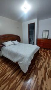阿亚库乔Casa completa, 5 dormitorios y jardín的一间卧室配有一张床,铺有木地板