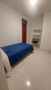 阿亚库乔Casa completa, 5 dormitorios y jardín的一间卧室配有一张带蓝色毯子的床