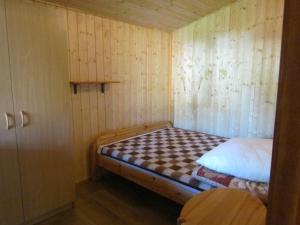 梅尔诺OW ZŁOTA PLAŻA的小房间,木墙里设有一张床