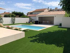 阿尔勒Casa del Sol - Piscine chauffée的后院设有游泳池和绿草