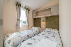Longniddry3 Bed Static Caravan-Seton Sands的配有2张床的小卧室设有窗户