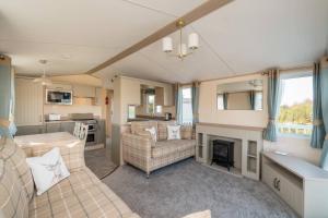 Longniddry3 Bed Static Caravan-Seton Sands的带沙发和壁炉的客厅