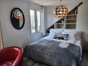 斯塔万格Cozee Central Apartments的一间卧室配有一张床和一张红色椅子