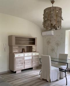 阿维利亚纳Novecento Charming Room的一间带玻璃桌和吊灯的用餐室