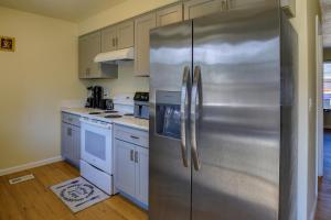 波特兰Portland Vacation Rental with Fireplace - Near Parks的一间厨房内的不锈钢冰箱,厨房内有白色的橱柜