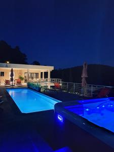拉莫特Les Hauts du Peireguier的夜间游泳池与房子