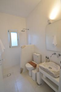 普恩达日落公寓的白色的浴室设有卫生间和水槽。