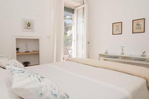 卡普里Casa Rubina的白色的卧室设有床和窗户