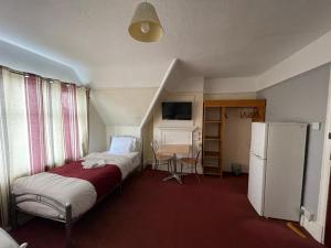 KentonST NICHOLAS HOTEL的小房间设有两张床和一台冰箱