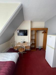 KentonST NICHOLAS HOTEL的客房设有床、桌子和冰箱。