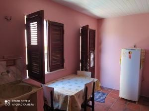 卡诺格布拉达Suítes D'Belinha的客房内的厨房配有桌子和冰箱