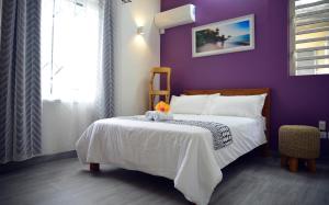 马埃堡Mahebourg Family Home的紫色卧室,床上有种动物