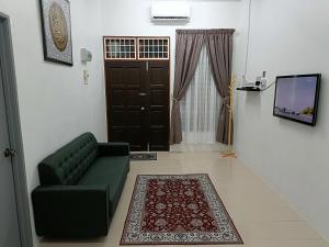 日得拉Adempuri Homestay 3的客厅设有绿色沙发和门。