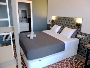 巴塞罗那法布里吉奥佩蒂特旅馆的一间卧室配有一张大床和镜子