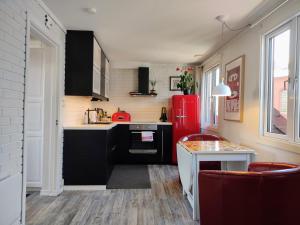 斯塔万格Cozee Central Apartments的厨房配有黑色橱柜和红色冰箱