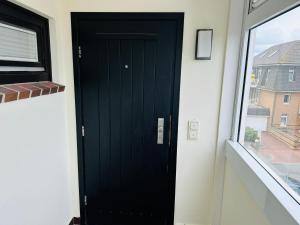 韦斯特兰Eidum 209 -strandnah-的窗户房间里一扇黑色的门