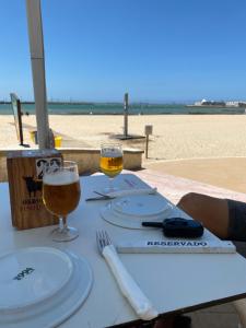 圣玛丽亚港Piso en la puntilla的海滩上的一张桌子和两杯啤酒