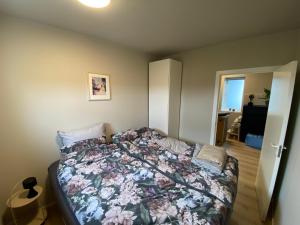 雷克雅未克Cosy modern apartment for up to 4 !的一间卧室配有一张带花卉床罩的床