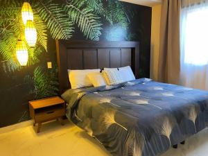 佩尼亚斯科港Urban Hotel Ancla Suite 10 - 3 Bedroom 2 Bathroom的一间卧室配有一张带大型植物墙的床