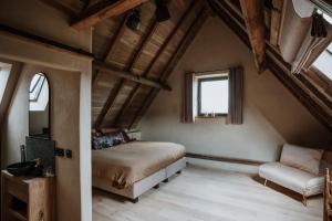 奥德纳尔德B@B Martinushoeve的一间卧室配有一张床、一张沙发和一个窗口