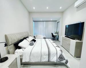 多拉多Ultimate Beach Getaway, Luxury villa in Ritz-Carlton, Dorado 5 mins to Beach的一间卧室配有一张大床和一台平面电视