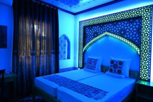 希瓦Khiva Tosh Darvoza的一间卧室配有一张蓝色灯光的床