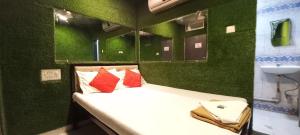 孟买Hotel Janata的绿色客房 - 带红色枕头的床