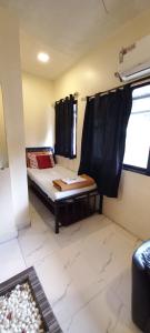 孟买Hotel Janata的小房间设有床和窗户