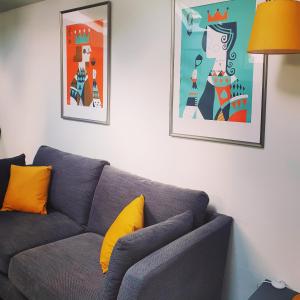 伍尔弗汉普顿West Park Annex Central Wolverhampton的客厅里一张灰色的沙发,有两张照片
