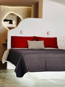 ProvatasCave Beach House Milos的一间卧室配有红色和白色枕头的床